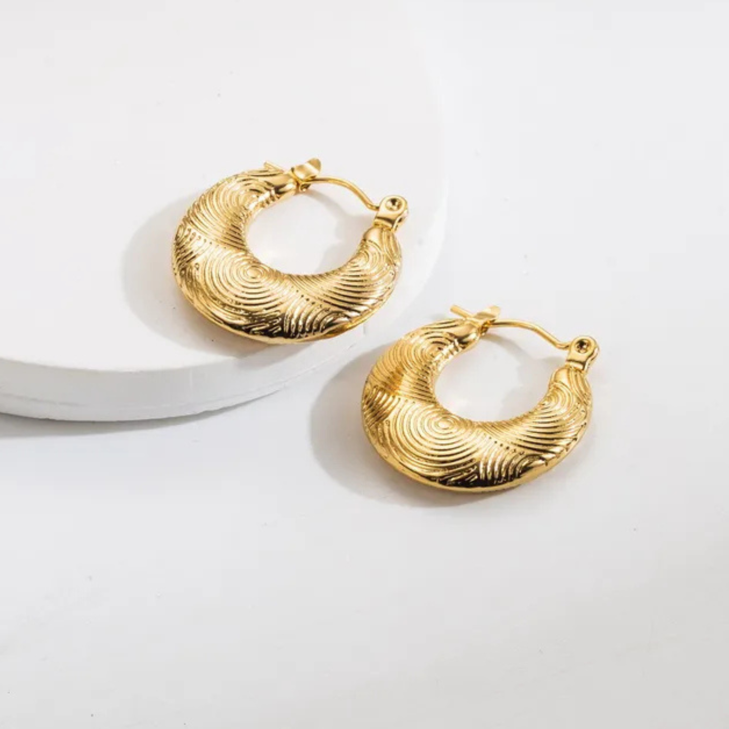 Gold hoop earrings on a white background