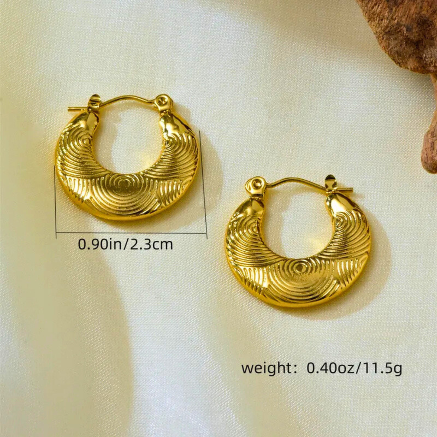 Gold hoop earrings with measurements and weight displayed on a light background
