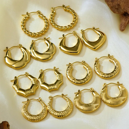 Collection of gold hoop earrings on a light background