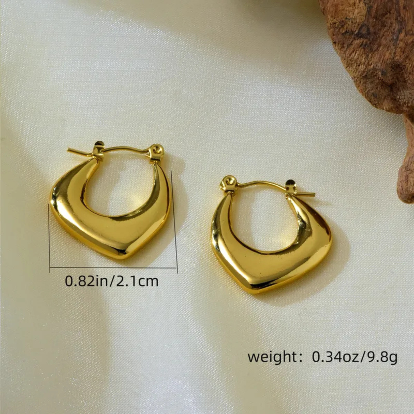 Gold hoop earrings on a light fabric background with measurements and weight displayed.