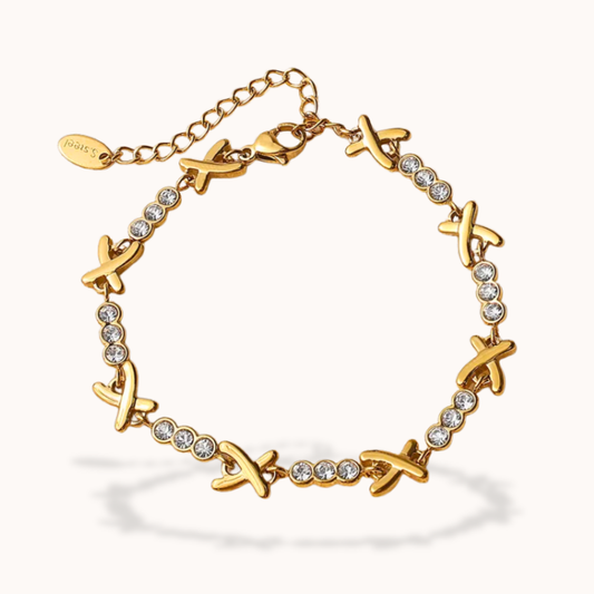 Gold bracelet with 'X' charms and clear stones on a white background