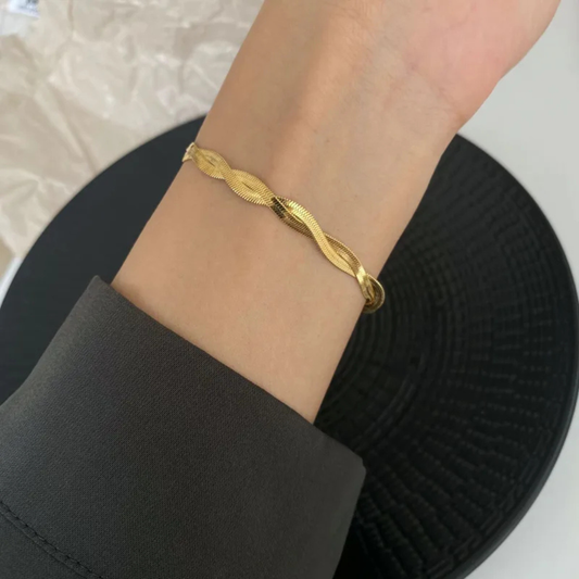 Gold bracelet on a person's wrist with a blurred background
