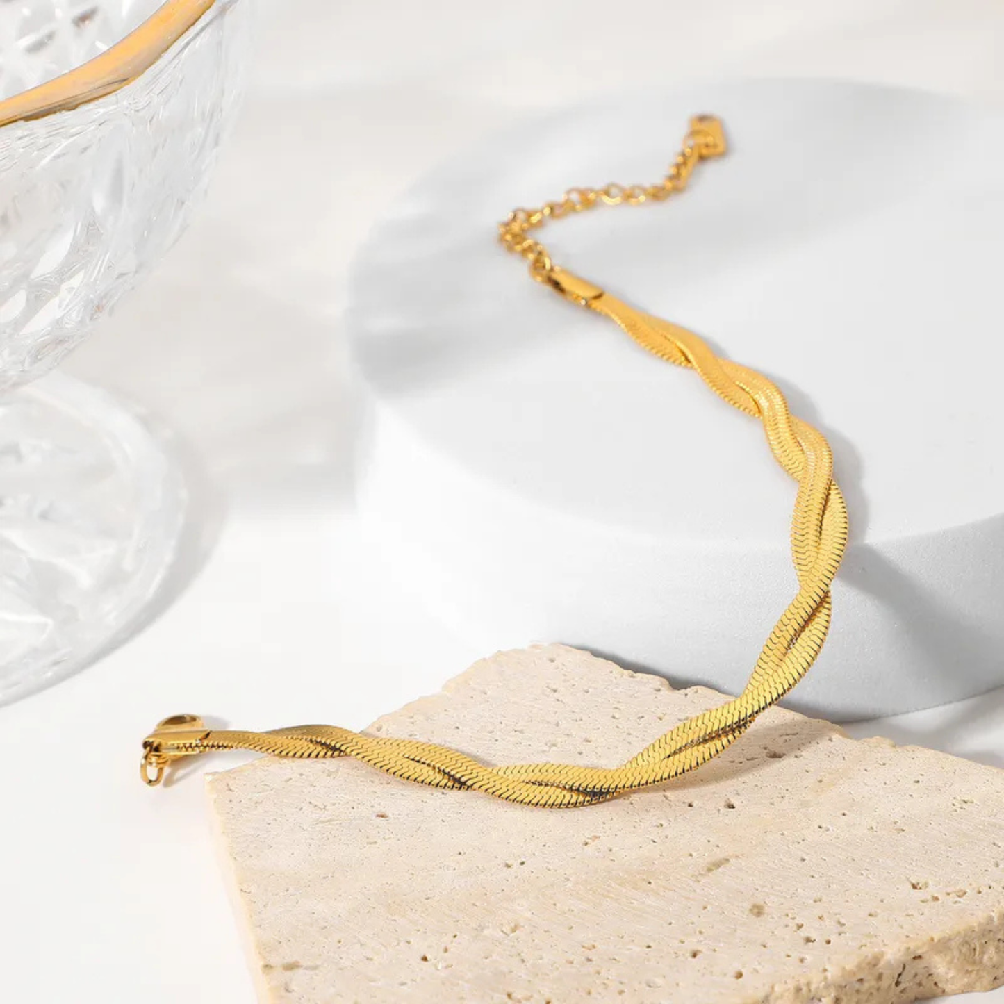 Gold necklace on a textured white surface