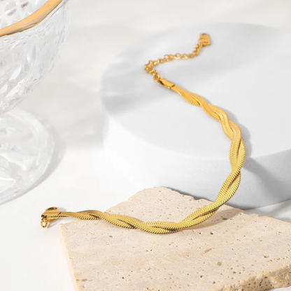 Gold necklace on a textured white surface