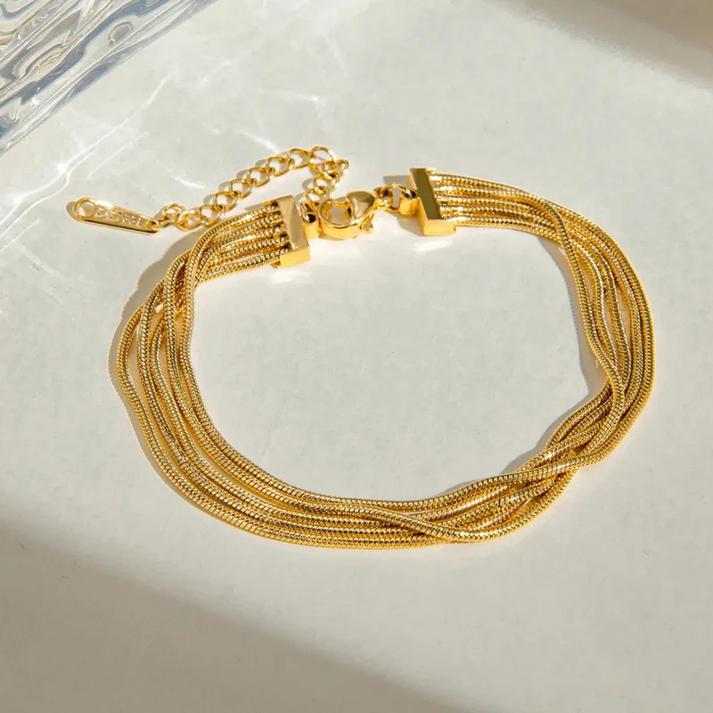 Gold bracelet with multiple strands on a light background