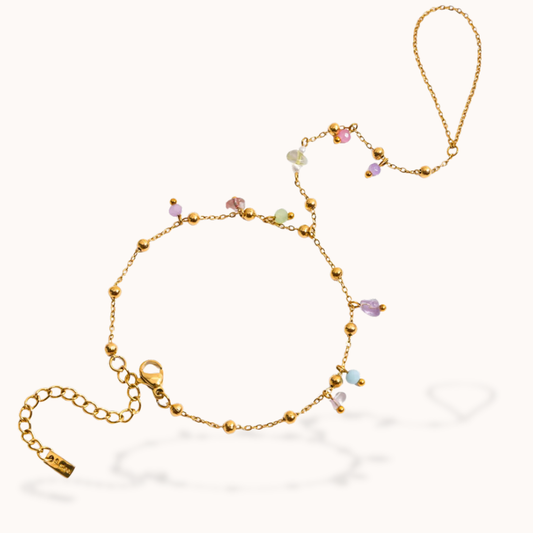 Gold bracelet with multicolored beads on a white background