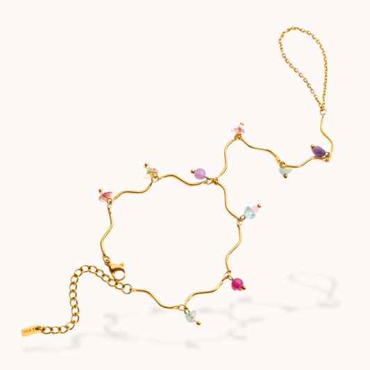 Gold bracelet with colorful beads on a white background