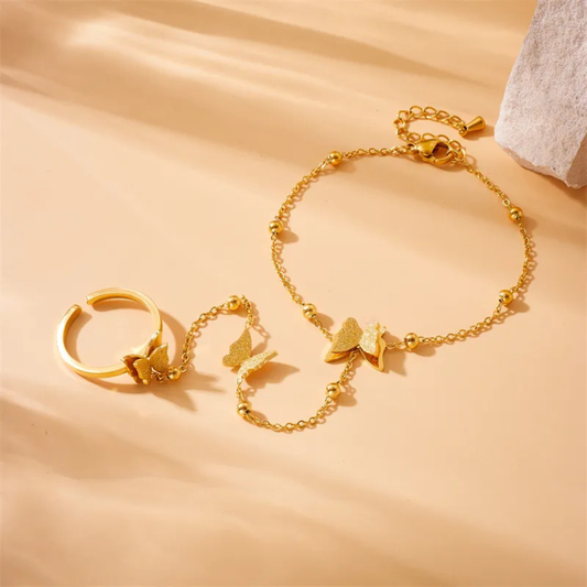 Gold bracelet and ring set on a beige background
