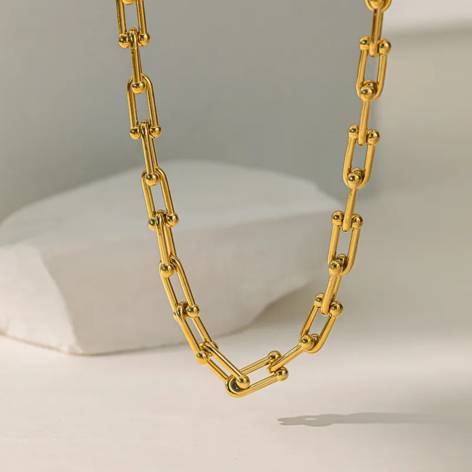 Gold chain necklace on a neutral background