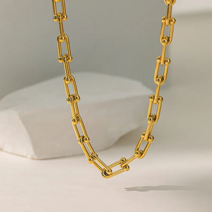 Gold chain necklace on a neutral background