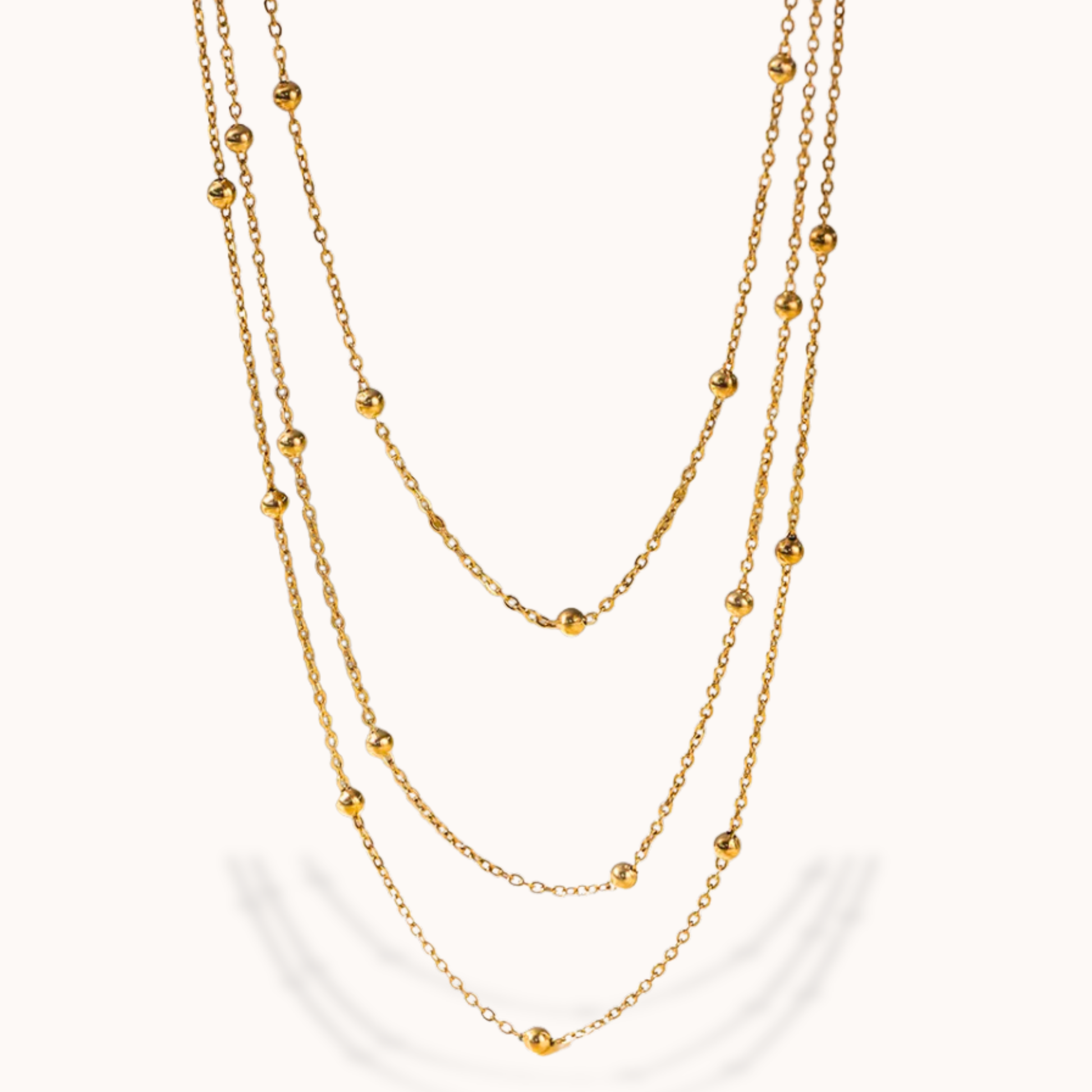 Gold chain necklace with small beads on a white background