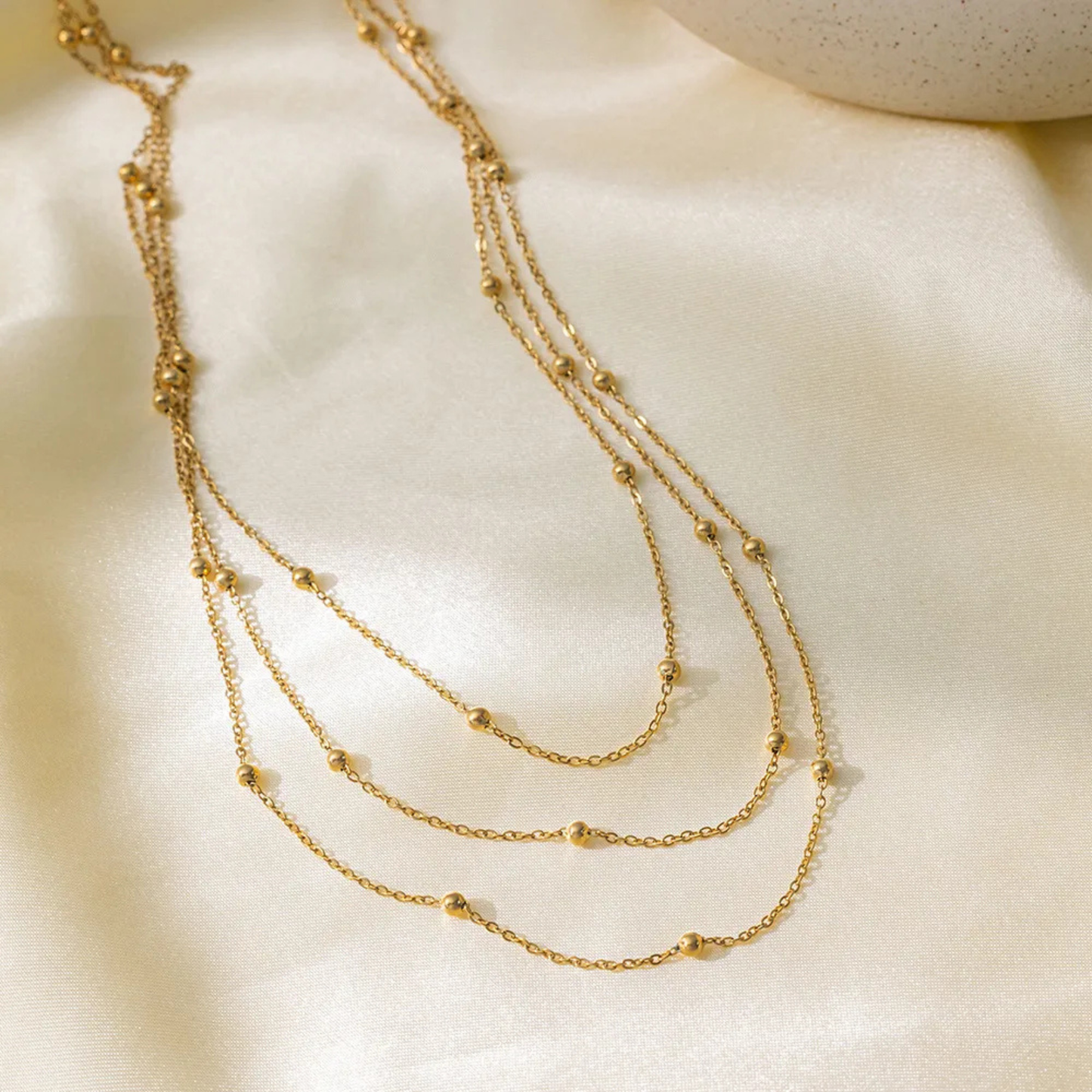Gold necklace on a beige fabric background