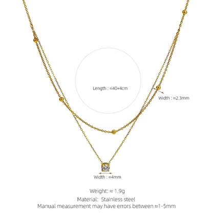 Gold necklace with measurement details on a white background