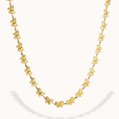 Gold butterfly necklace on a white background