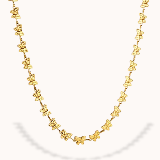 Gold butterfly necklace on a white background