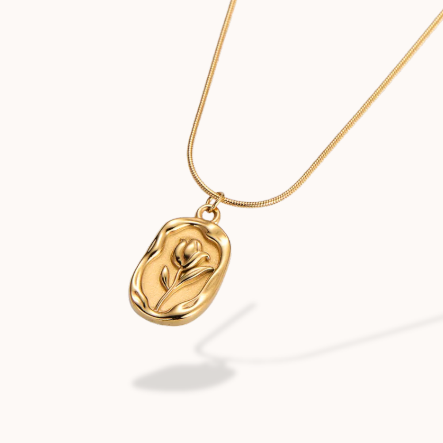 Gold rose pendant necklace on a white background
