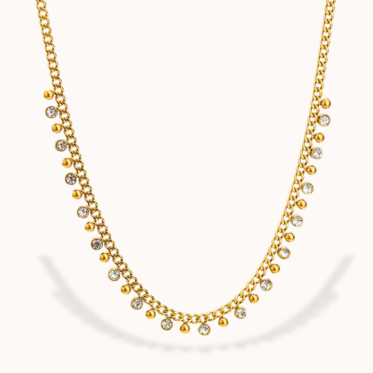Gold necklace with small beads on a white background