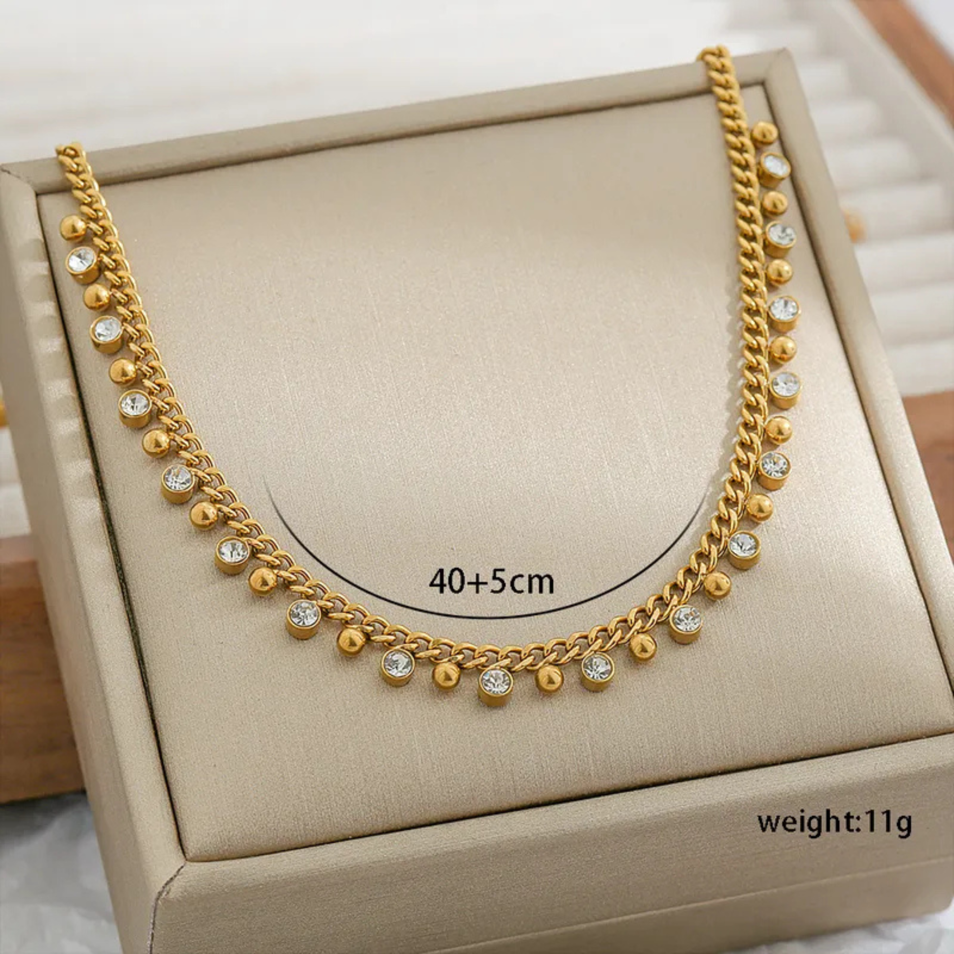 Gold necklace with small diamonds on a beige jewelry box