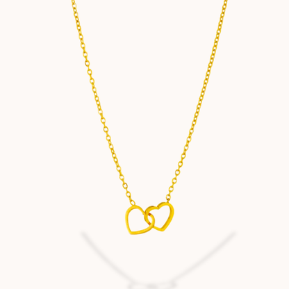 Gold necklace with interlocking heart pendants on a white background