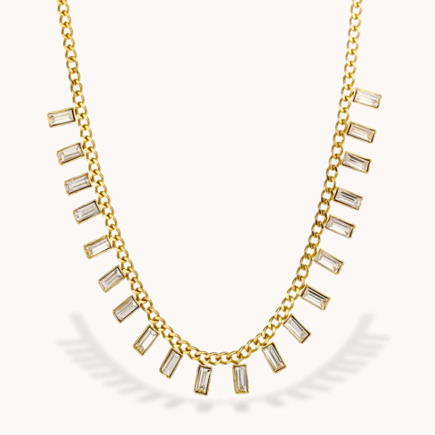 Gold necklace with baguette cut gemstones on a white background