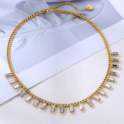 Gold necklace with clear stones on a light background