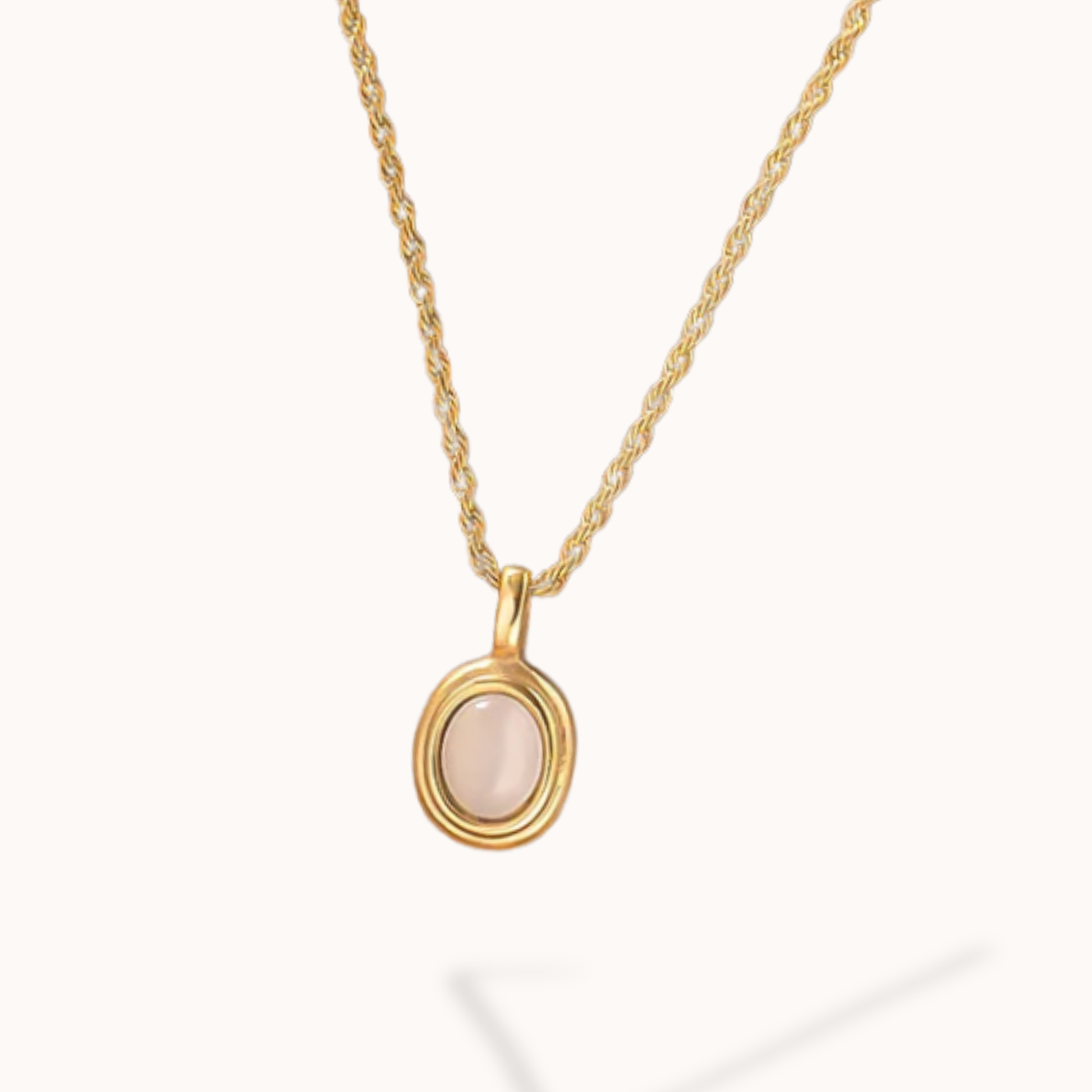 Gold necklace with a white stone pendant on a white background