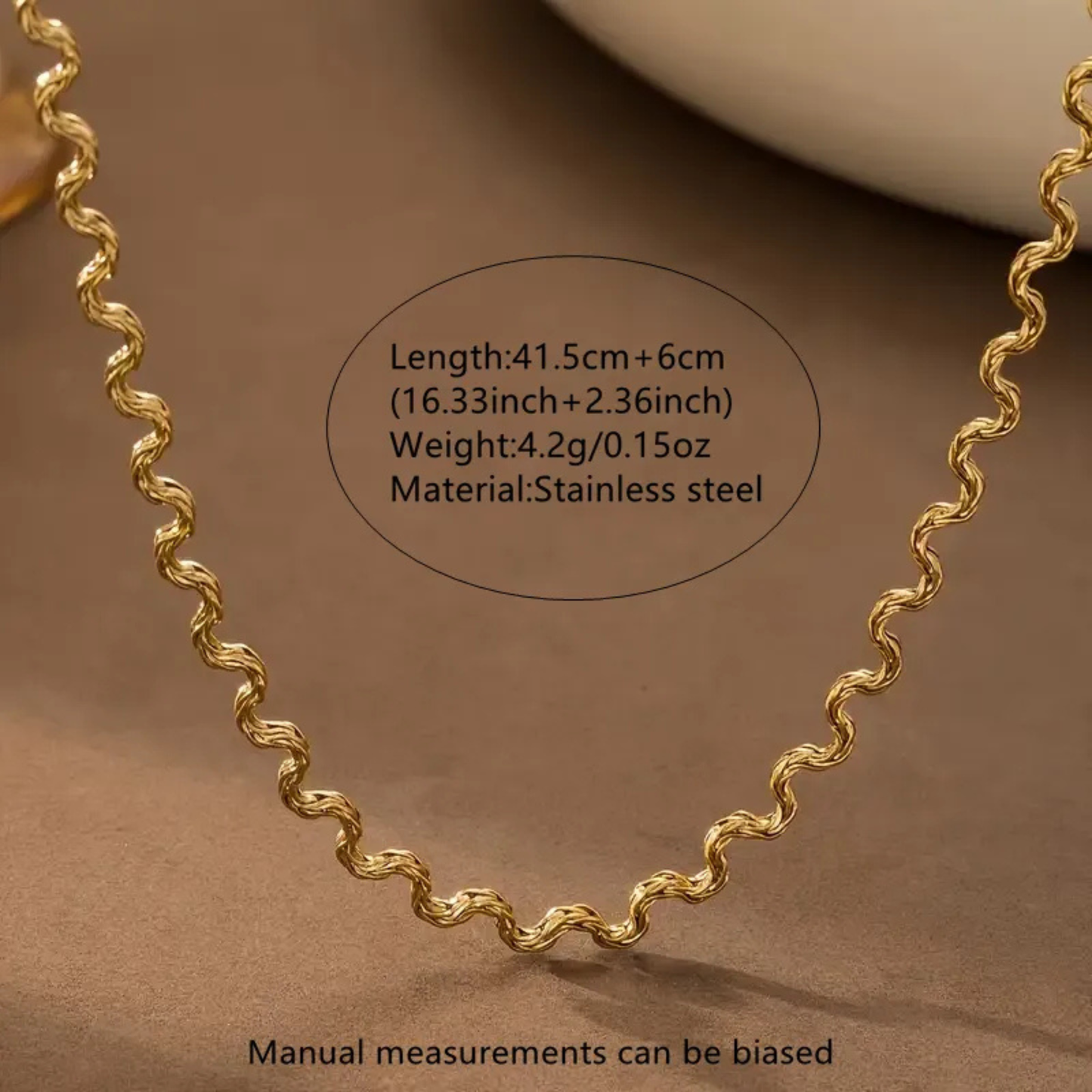 Gold chain with measurements and material details on a brown background