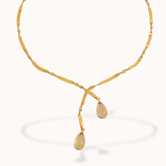 Gold necklace with teardrop-shaped pendants on a white background