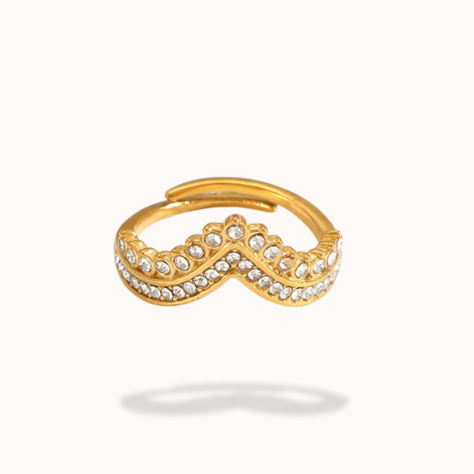 Gold ring with a diamond infinity symbol on a white background