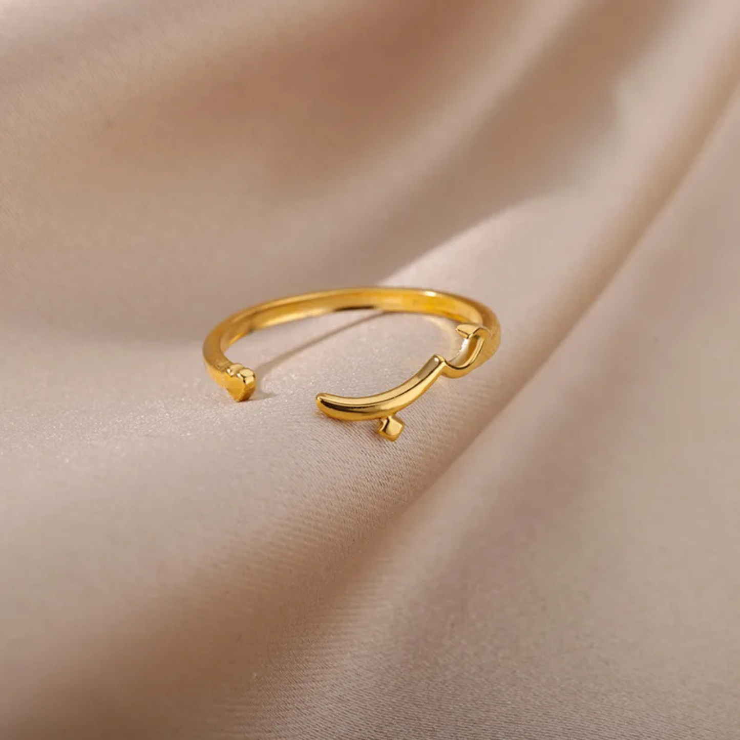 Gold open ring on a beige fabric background