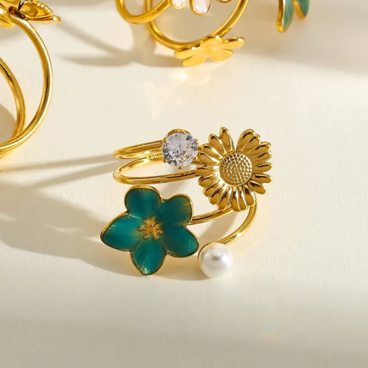 Gold ring with floral and pearl designs on a light background