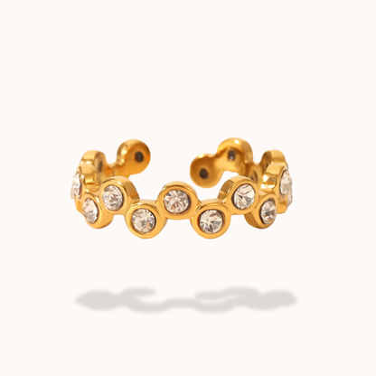 Gold ring with embedded crystals on a white background
