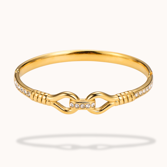 Gold bracelet with diamond accents on a white background