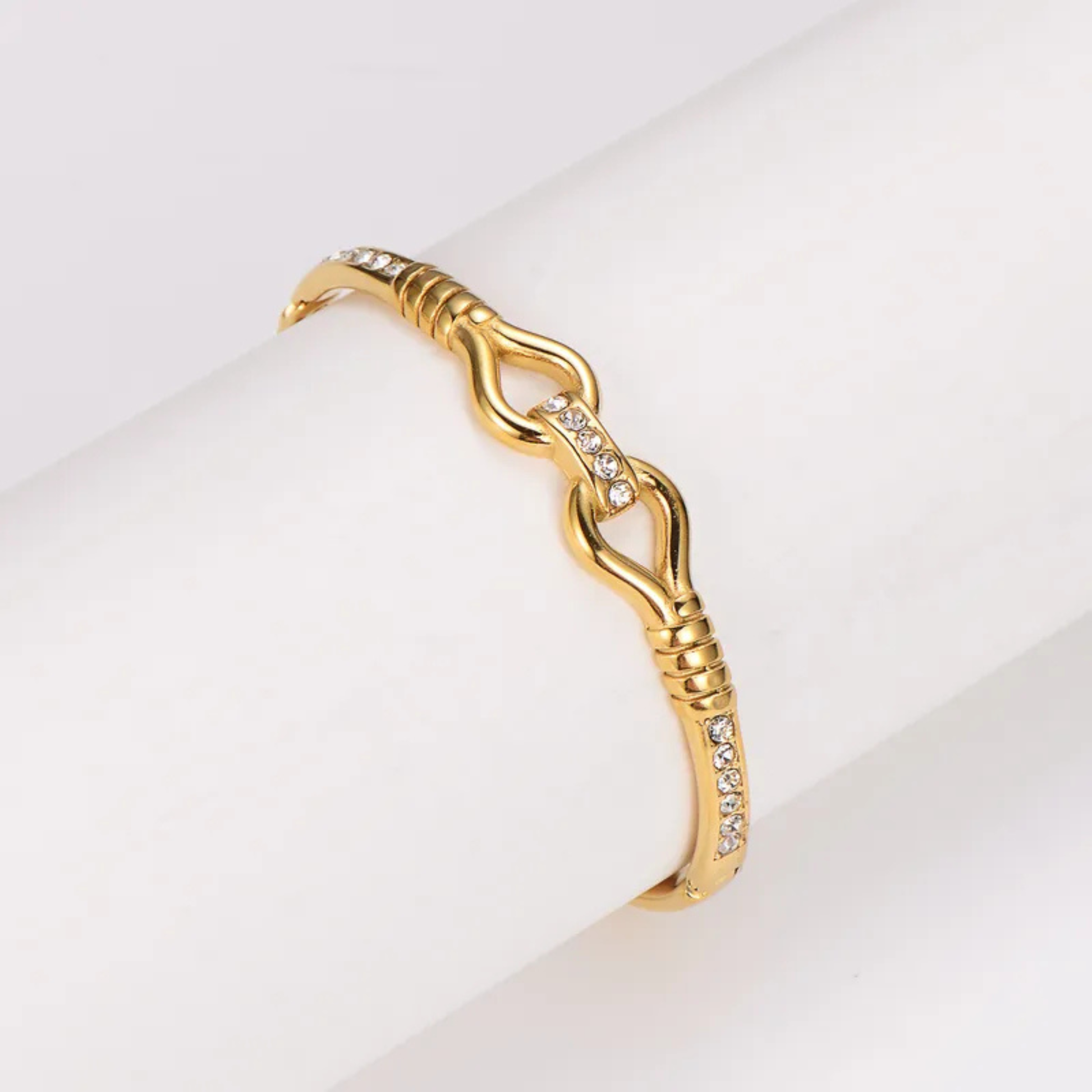 Gold bracelet with intricate design on a light background