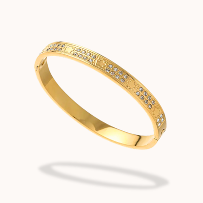 Gold bracelet with embedded stones on a white background