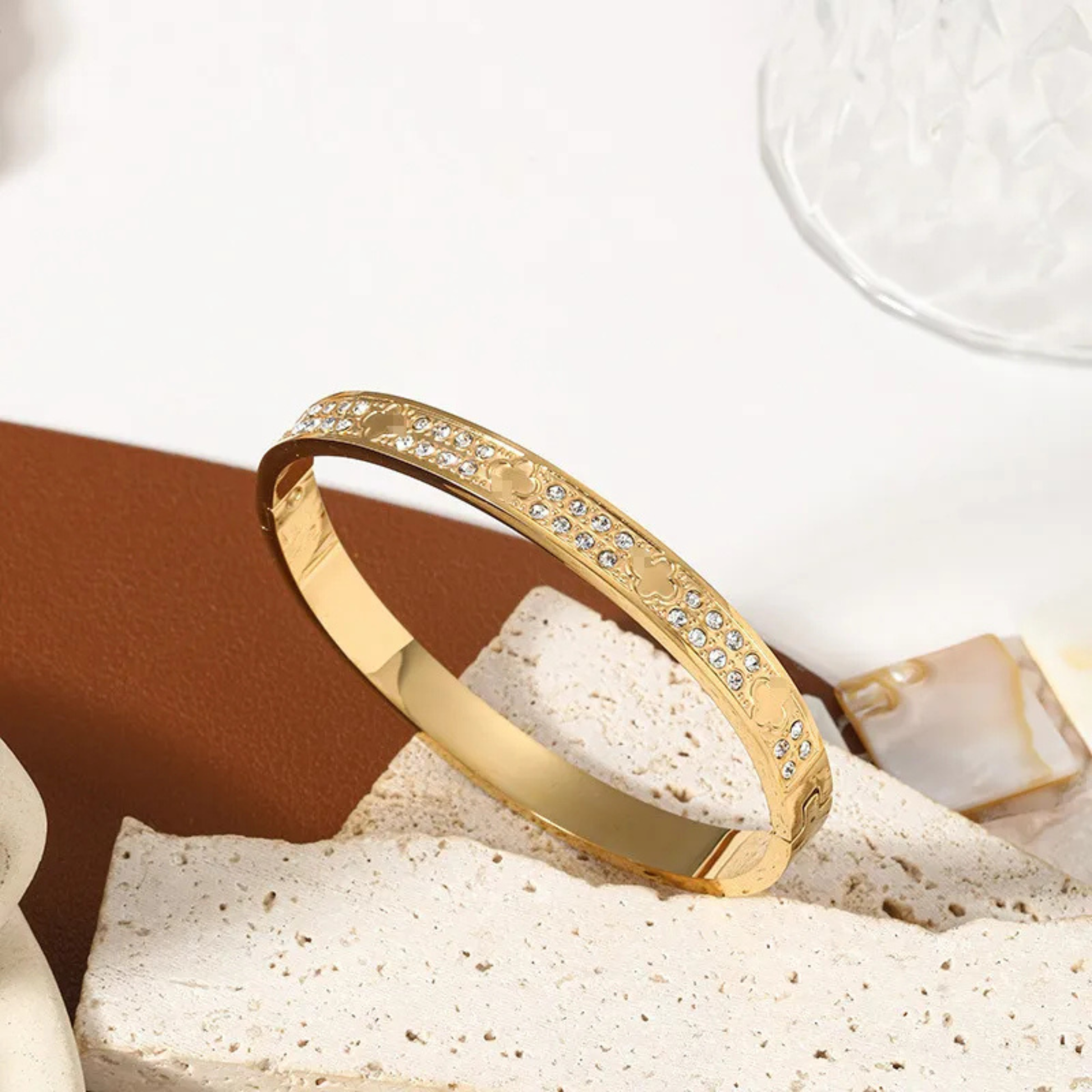 Gold bracelet with embedded stones on a textured surface