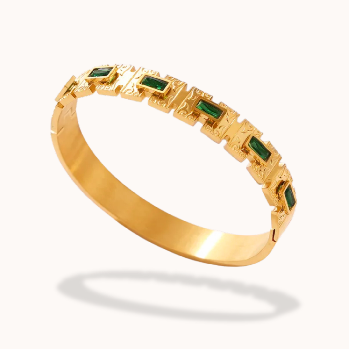 Gold bracelet with green gemstones on a white background