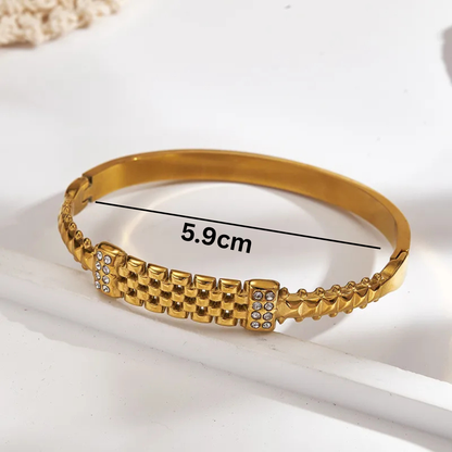 Gold bracelet with measurement text on a white background