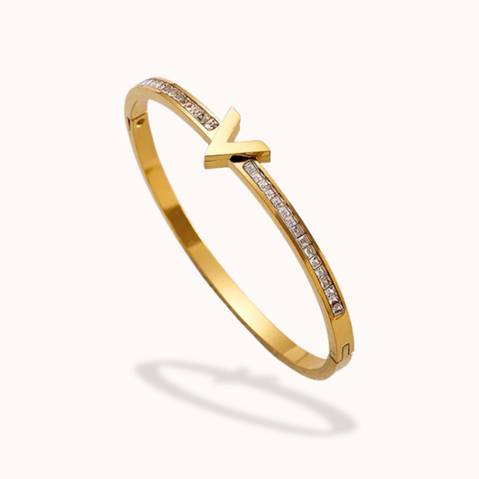 Gold bracelet with an arrow design on a white background