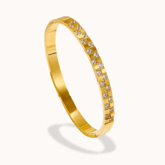 Gold bracelet with embedded diamonds on a white background