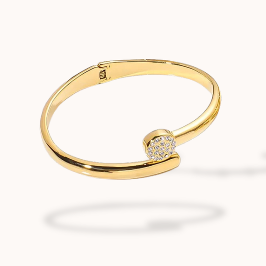 Gold bracelet with a diamond clasp on a white background