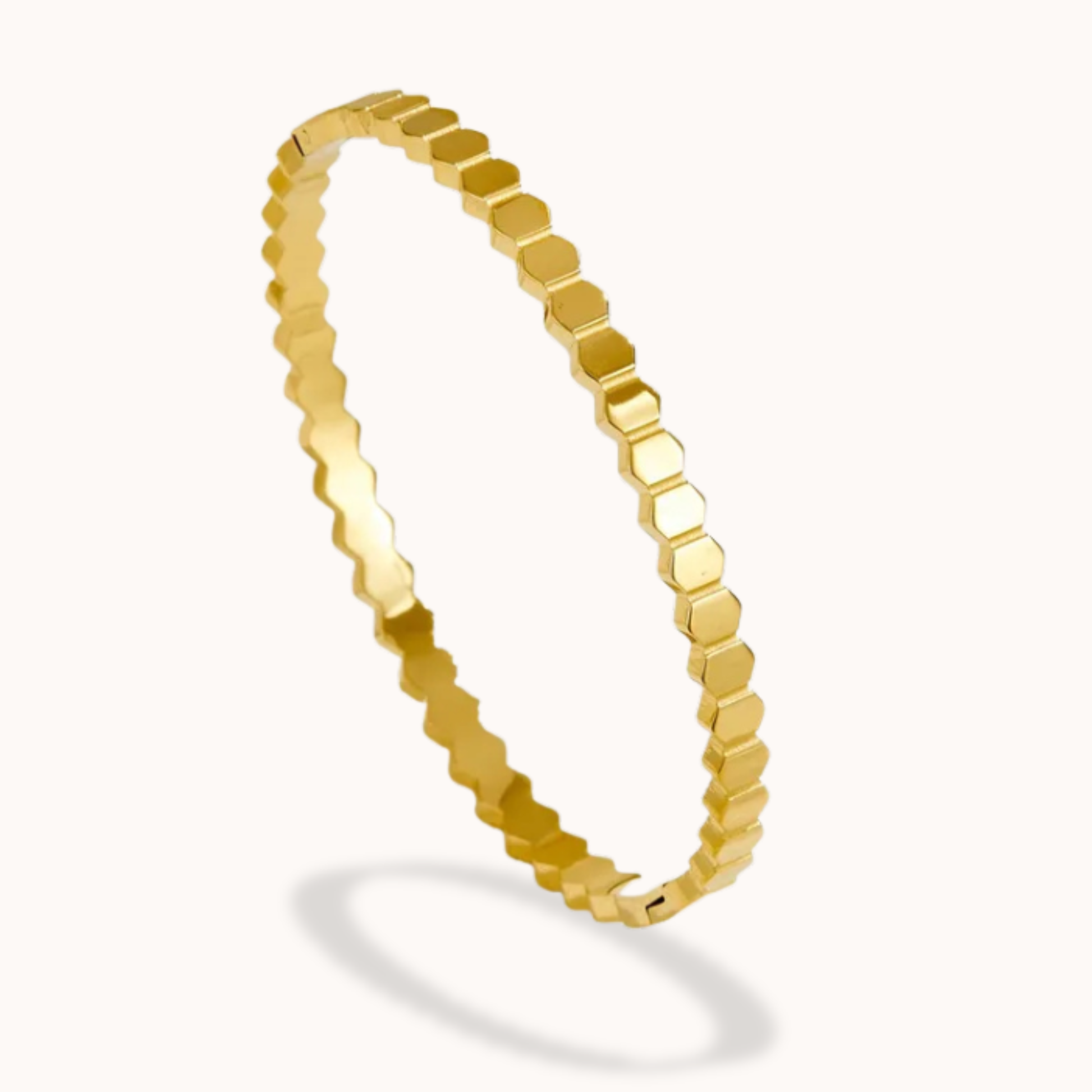 Gold bracelet with a hexagonal pattern on a white background