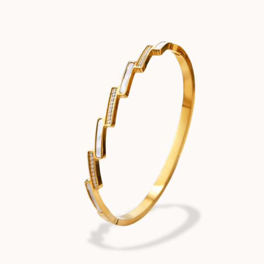 Gold bracelet with diamond accents on a white background