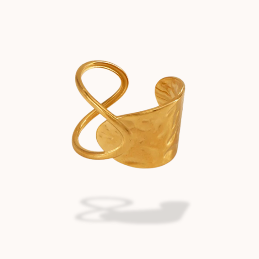 Gold infinity-shaped ring on a white background