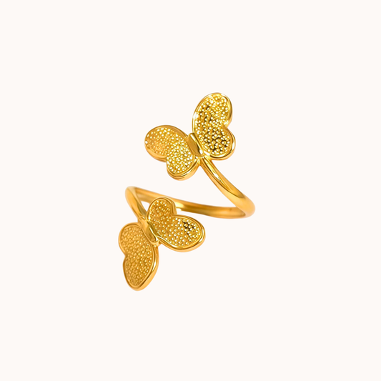 Gold butterfly-shaped ring on a white background