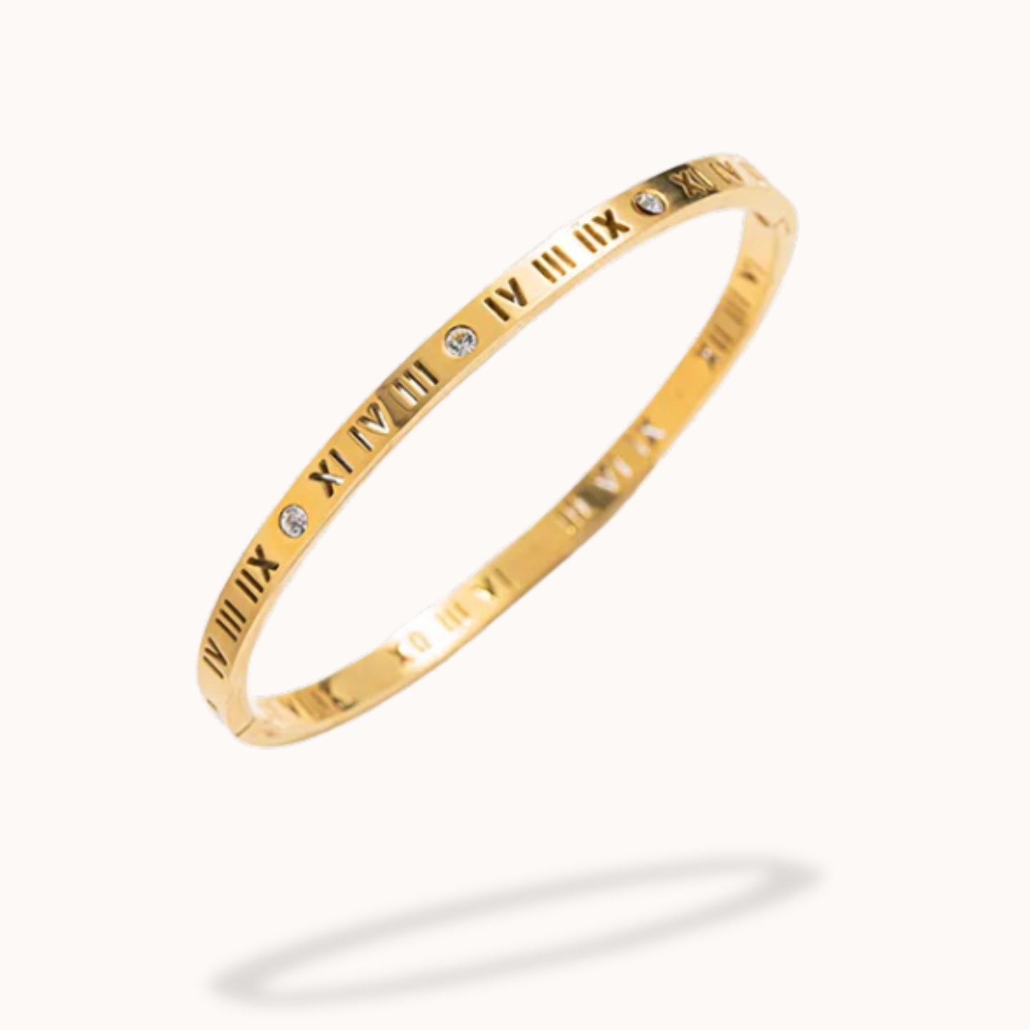 Gold bracelet with Roman numeral markings on a white background