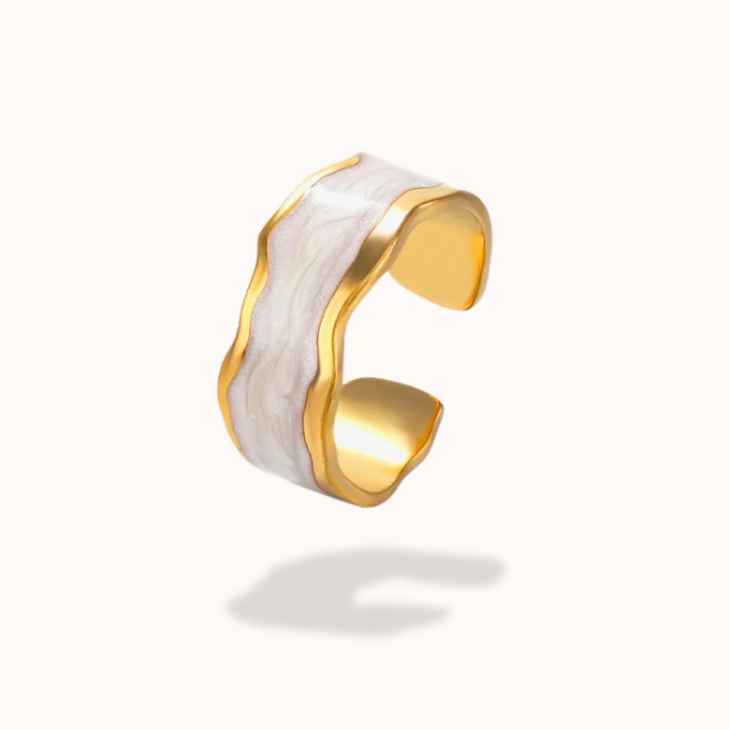 Gold and white cuff bracelet on a white background