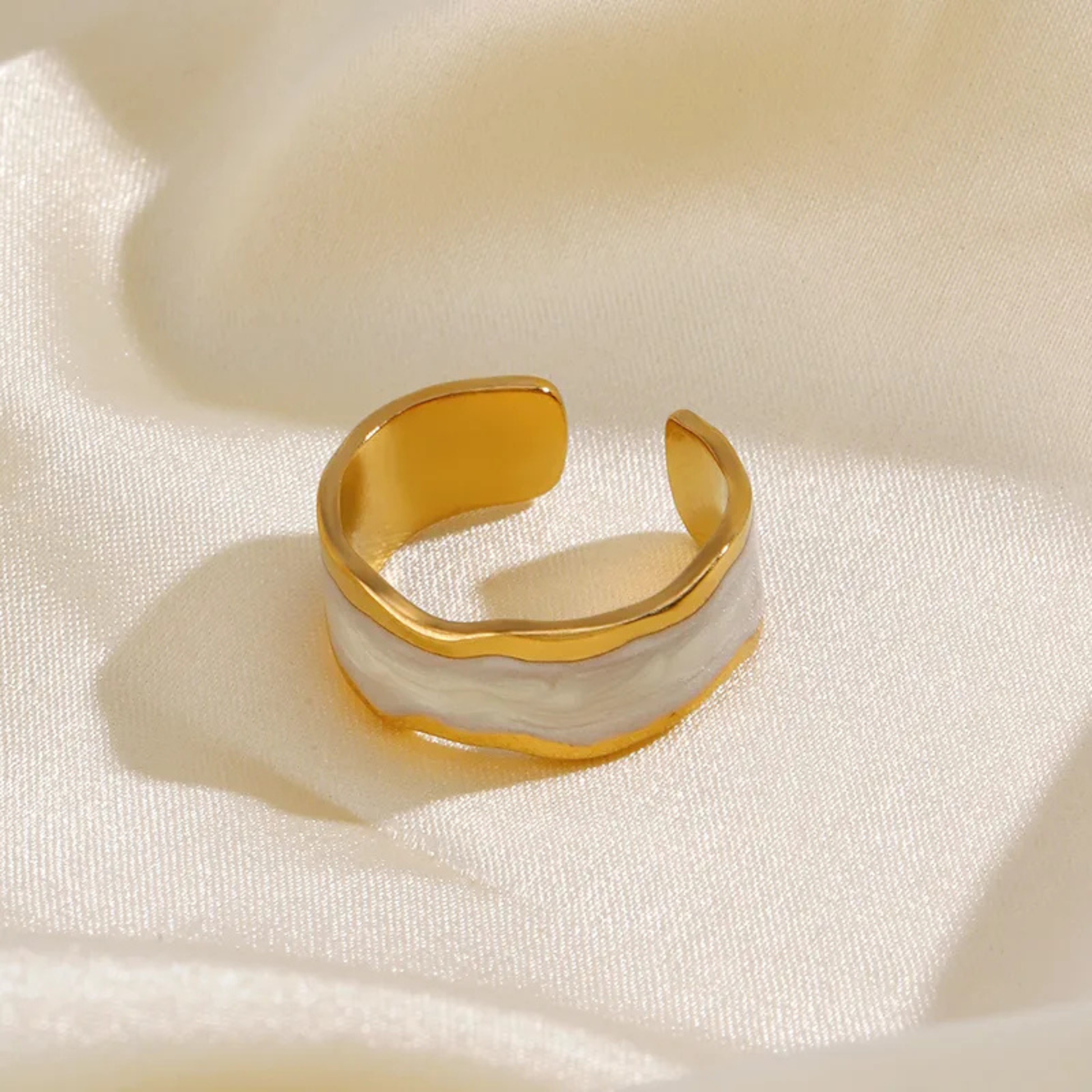 Gold and white ring on a beige fabric background