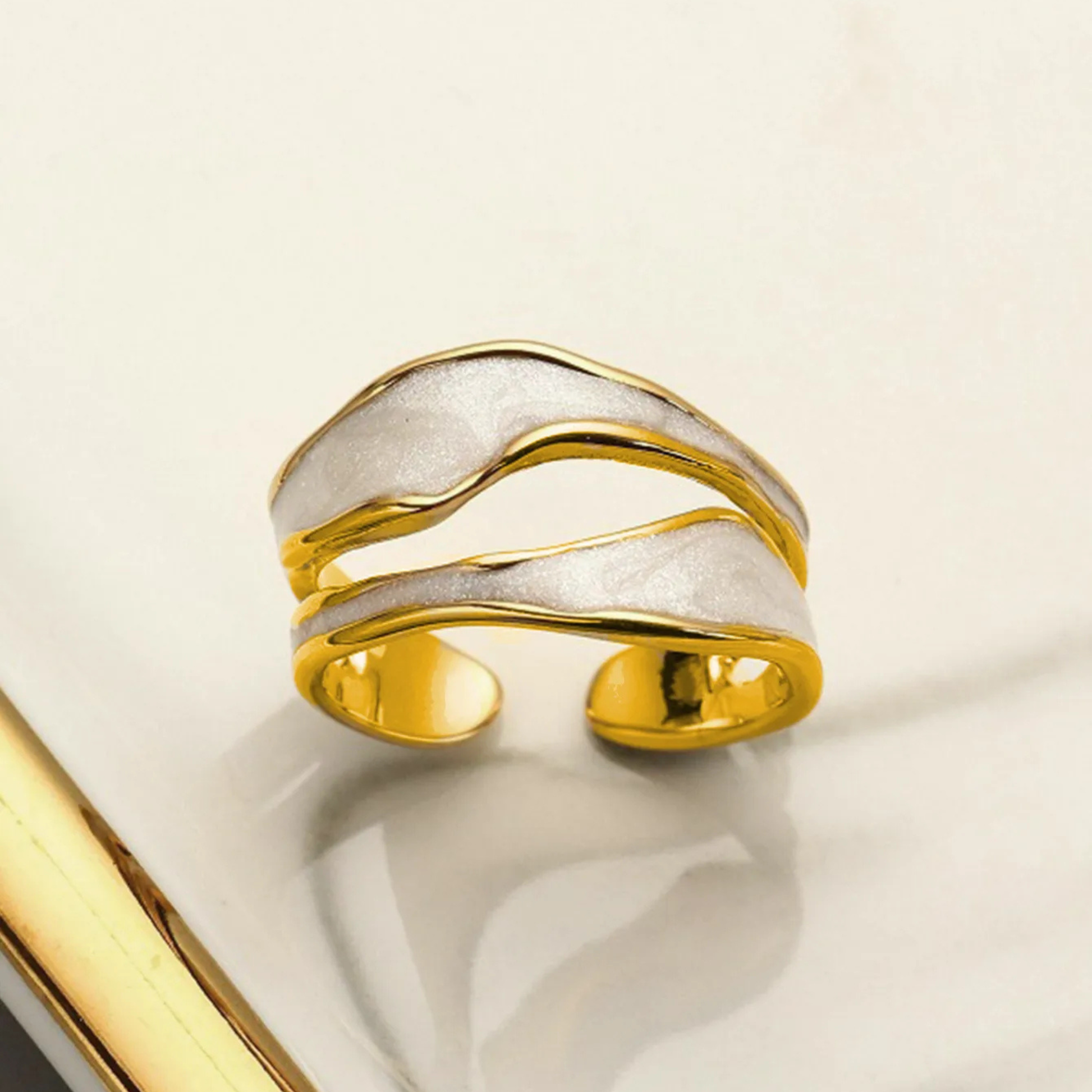 Gold and silver ring on a light beige background