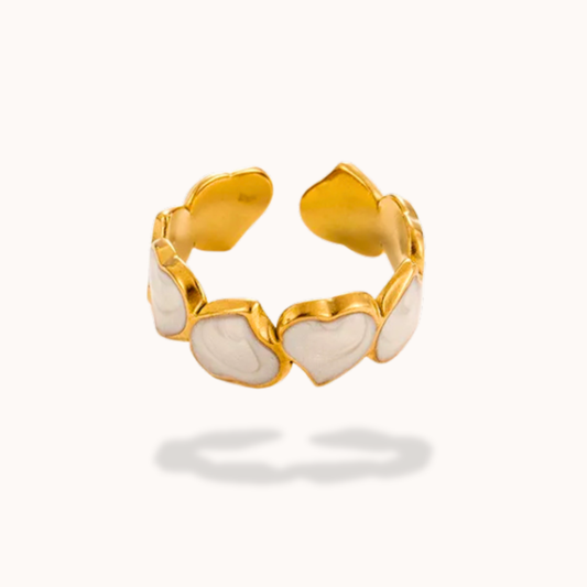 Gold ring with heart-shaped stones on a white background